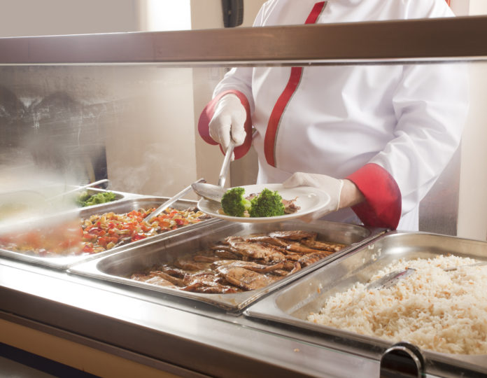 Chef Standing Behind Full Lunch Service Station