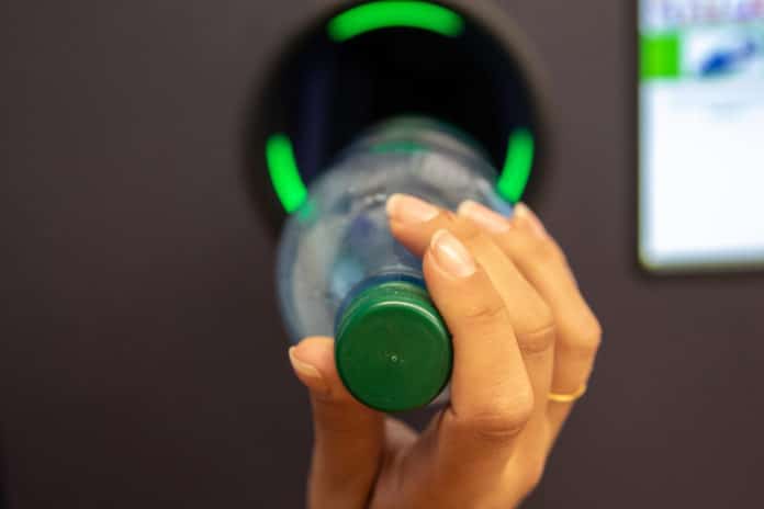 Junge Frau Wirft Pfandflaschen In Automaten