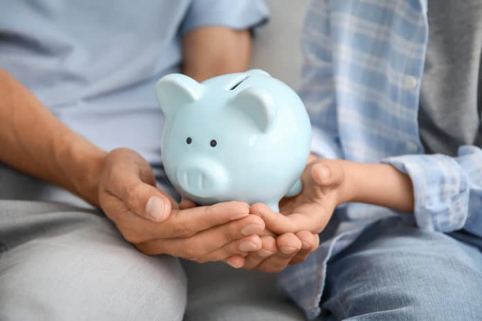 Family With Piggy Bank At Home, Closeup