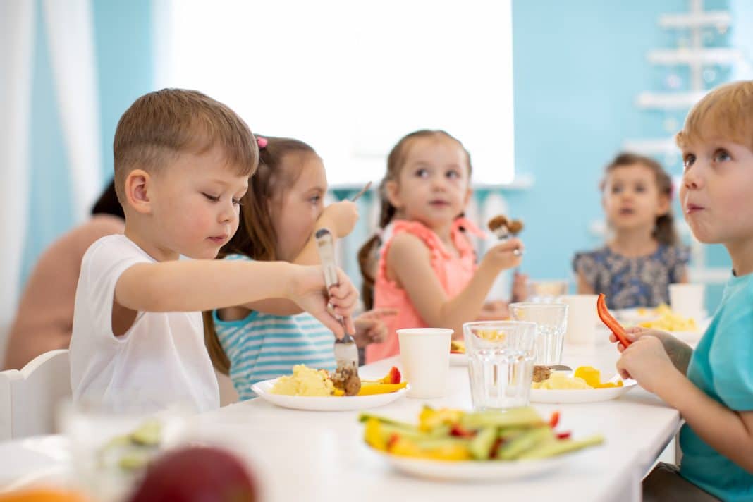Kids Enjoying Healthy Lunch In Kindergarten