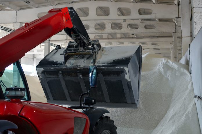 Loader Loading Jumbo Bags With White Urea Fertilizer In The Warehouse. Selective Focus.